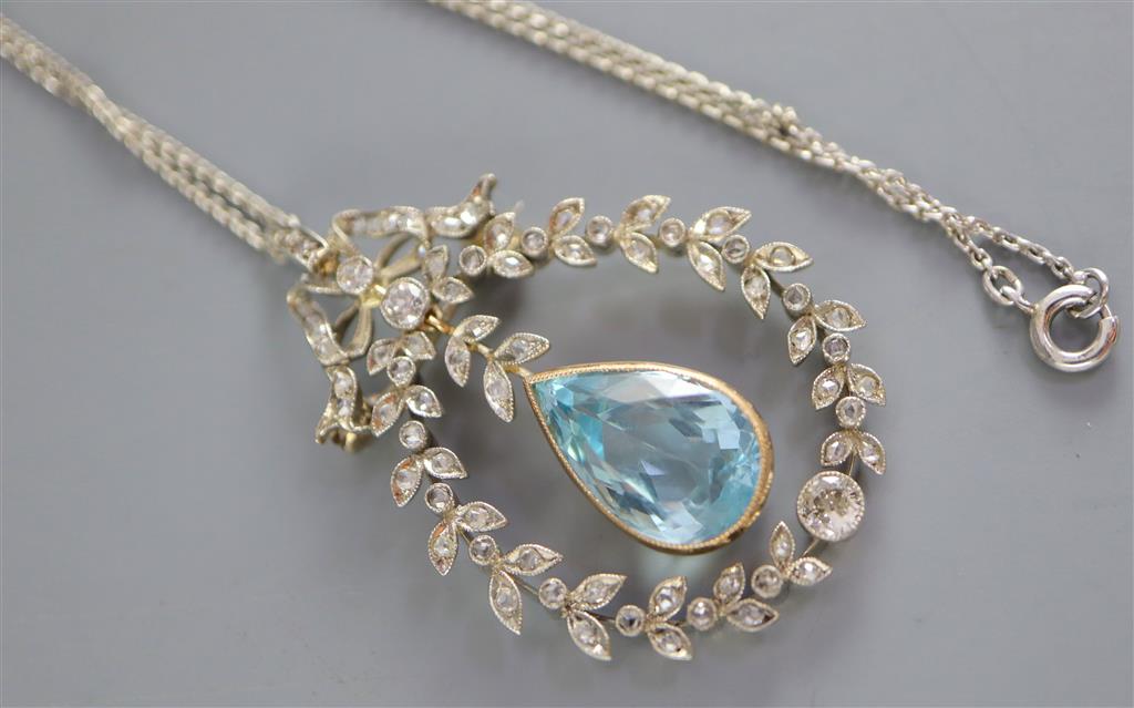 An Edwardian white and yellow gold, aquamarine and round and rose cut diamond set openwork drop pendant, on a fine link chain,